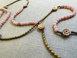 closeup view of gemstone bead necklace comprising antique hand-carved bone flowers, pink opal and gold hematite