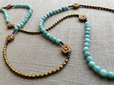  closeup view of gemstone bead necklace comprising antique hand-carved bone flowers, blue larimar and gold hematite
