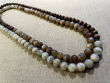 top view of gemstone bead necklace comprising peach moonstone, white siberian moonstone and brown exotic wood. 
