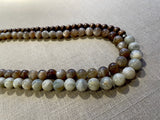 side view of gemstone bead necklace comprising peach moonstone, white siberian moonstone and brown exotic wood. 