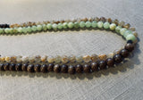 side view of gemstone bead necklace comprising green calcite, light yellow rutilated quartz and brown exotic wood. 