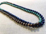 top view of gemstone bead necklace comprising blue lapis, green amazonite and brown exotic wood. 