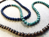 closeup view of gemstone bead necklace comprising blue lapis, green amazonite and brown exotic wood. 