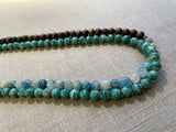 side view of gemstone bead necklace comprising blue azurite, green amazonite and brown exotic wood. 