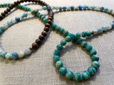 closeup view of gemstone bead necklace comprising blue azurite, green amazonite and brown exotic wood. 