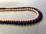 side view of gemstone bead necklace comprising pink opal, blue lapis and brown exotic wood. 
