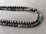 side view of gemstone bead necklace comprising tan prayer beads, black and white tourmalated quartz and exotic wood