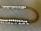 side view of gemstone bead necklace comprising black/white/nude feldspar, pink opal and gold hematite