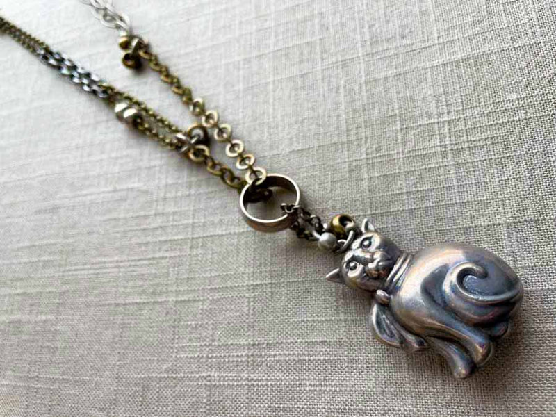 top view of antique sterling silver cat rattle pendant on chain mix