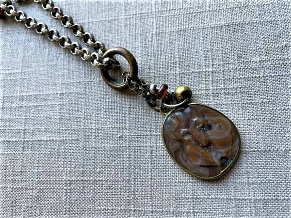 closeup of antique carved knight's face shield cameo pendant on chain mix