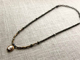 top view of antique cameo pendant hung on metallic bead choker