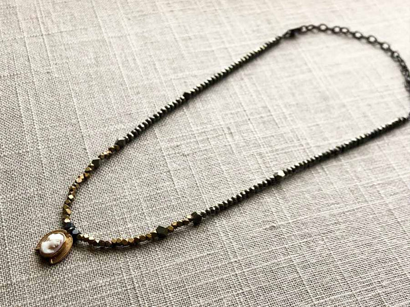 top view of antique cameo pendant hung on metallic bead choker
